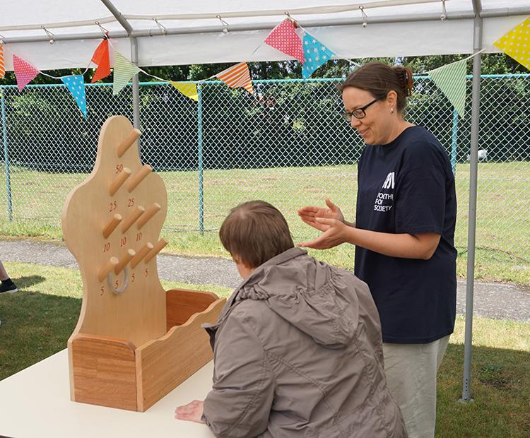 Vrijwilligers organiseren Vlaamse kermis voor cliënten MPI Oosterlo: spelletje ringen gooien.